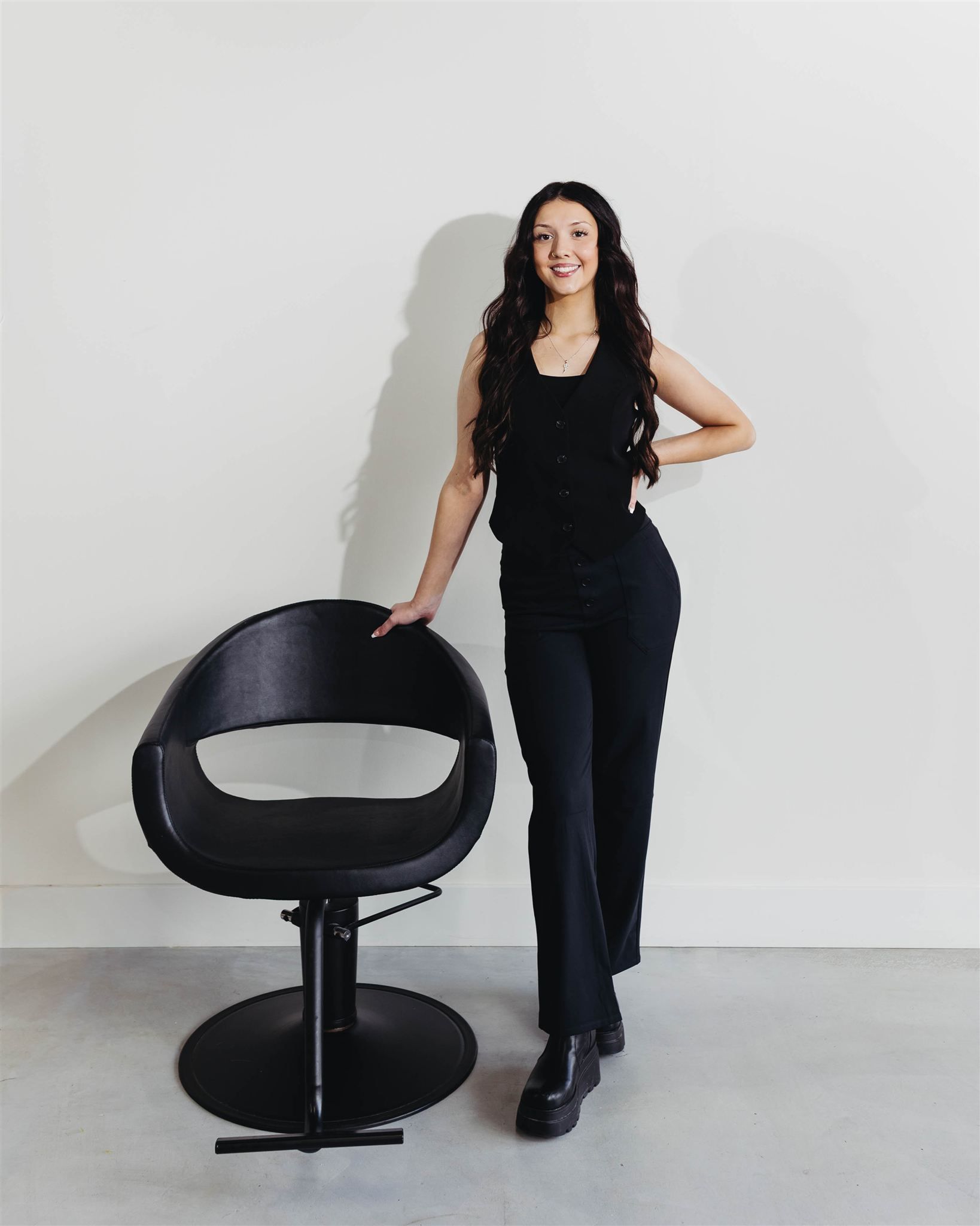 A woman is sitting in a chair in a hair salon