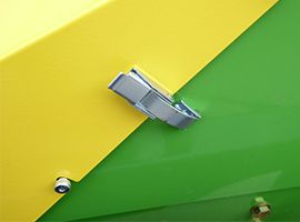 Close-up of a yellow and green metal surface with a silver latch in the center.
