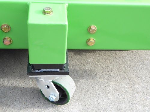 Close-up of a green metal frame with a small swivel caster wheel attached.