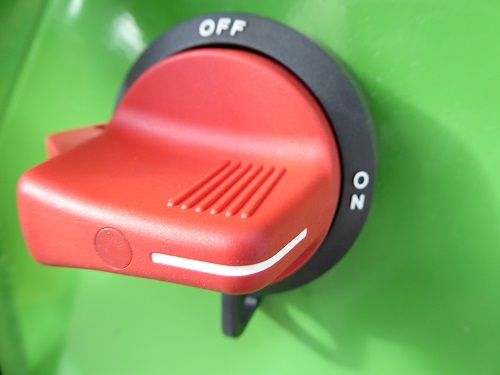 Red rotary power switch on a green machine, labeled OFF and ON.