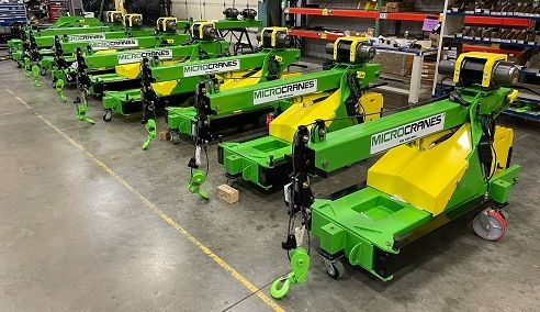 Rows of green and yellow agricultural machines lined up in a warehouse