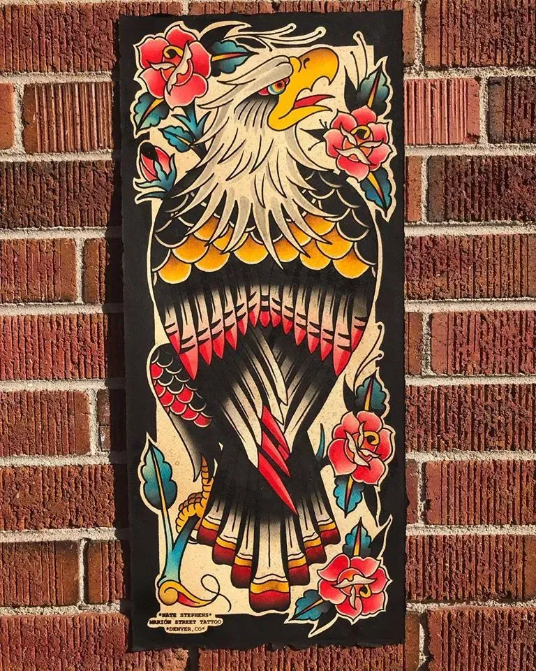 A painting of an eagle with feathers and flowers on a brick wall.