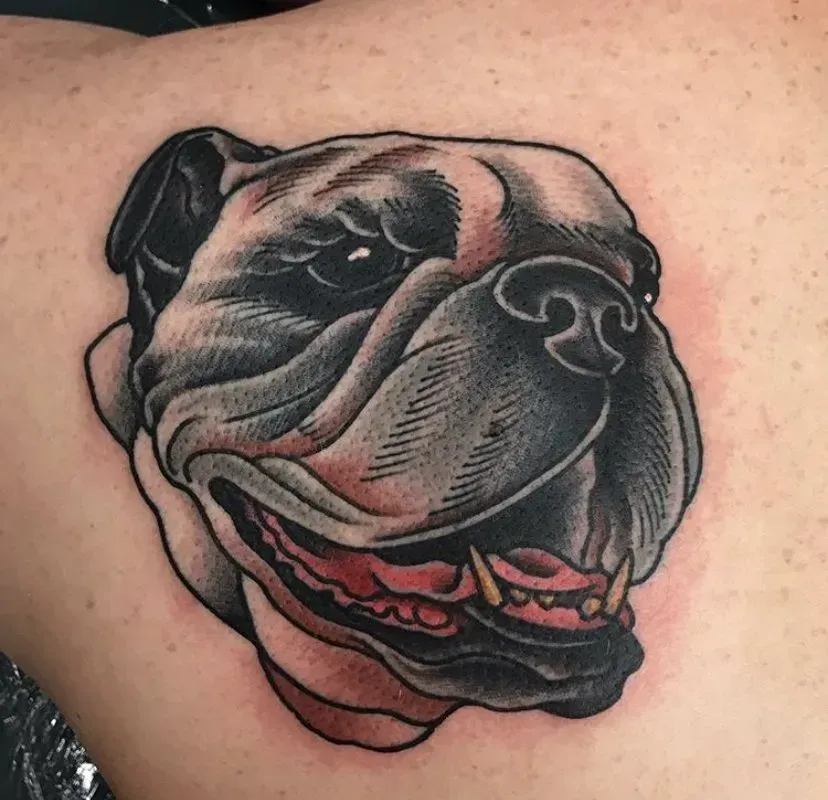 A close up of a tattoo of a bulldog on a person 's shoulder