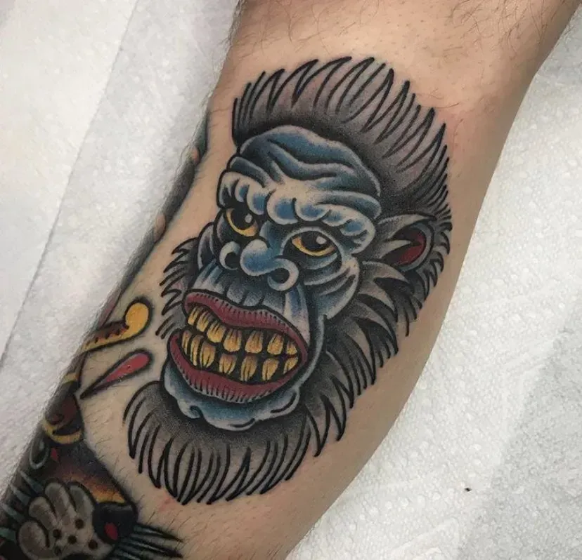 A man has a tattoo of a gorilla on his arm.