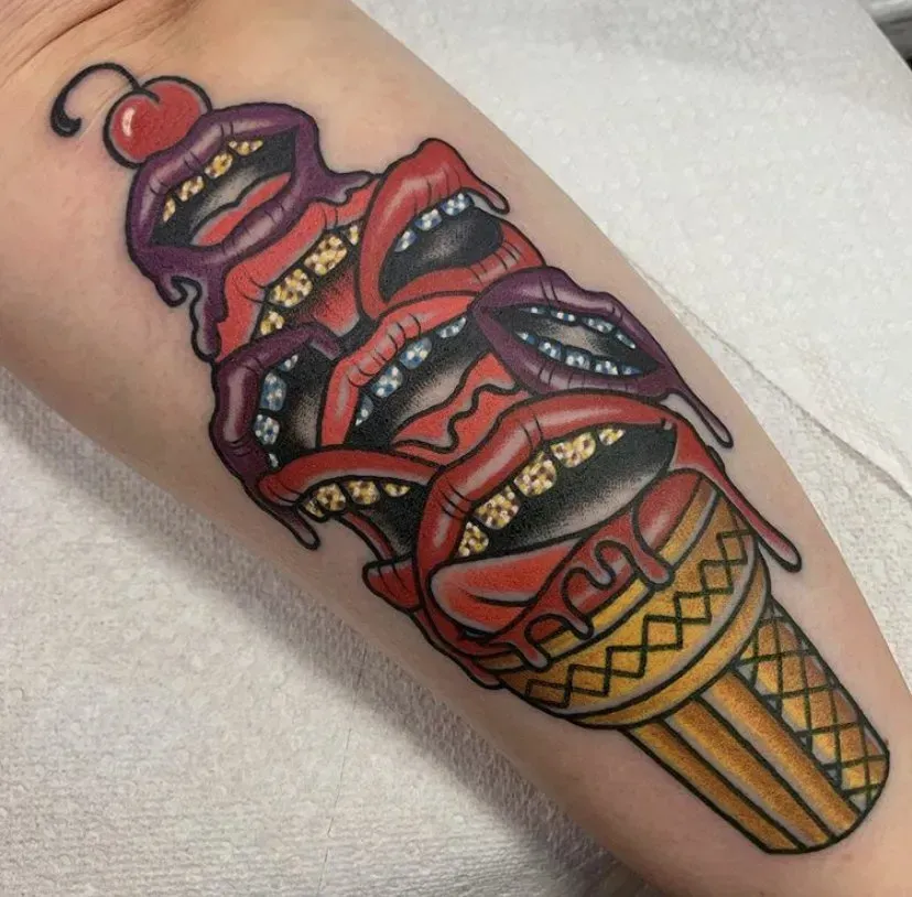 A tattoo of a ice cream cone with a cherry on top