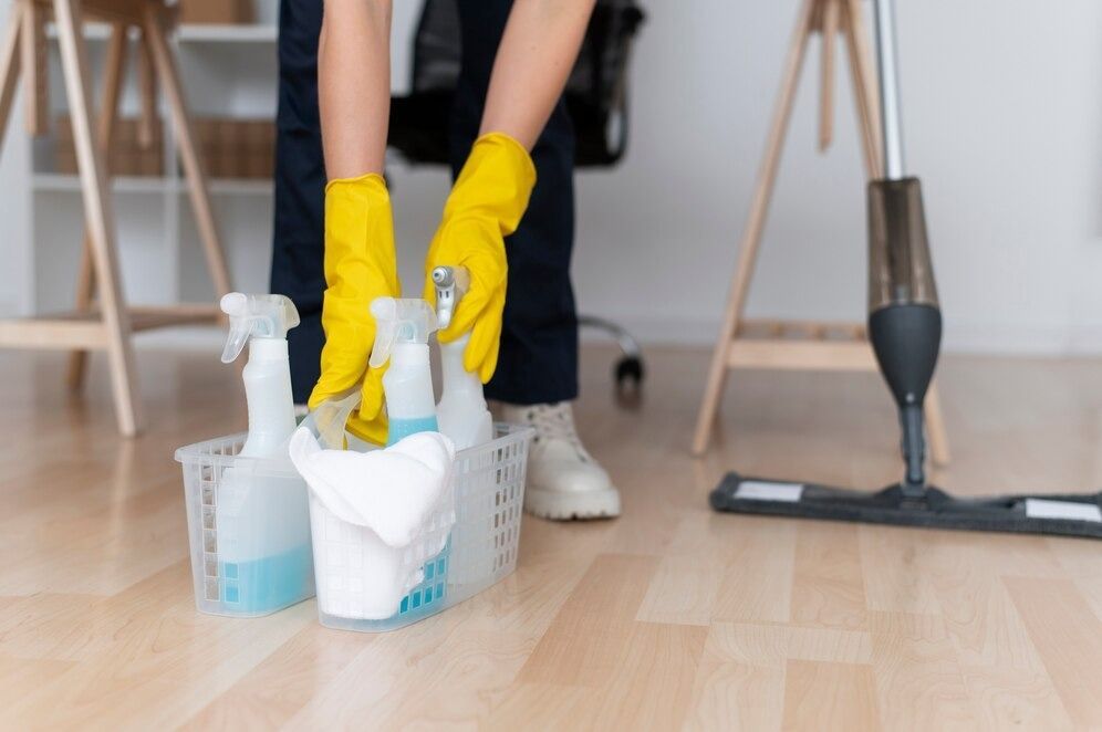 A Person Wearing Yellow Gloves Is Cleaning the Floor — Complete Clean Home Cleaning in Albion Park, NSW