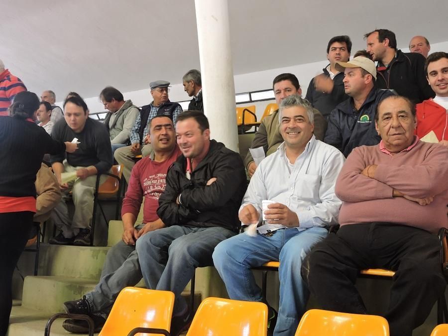 Un grupo de hombres está sentado en un estadio viendo un partido.