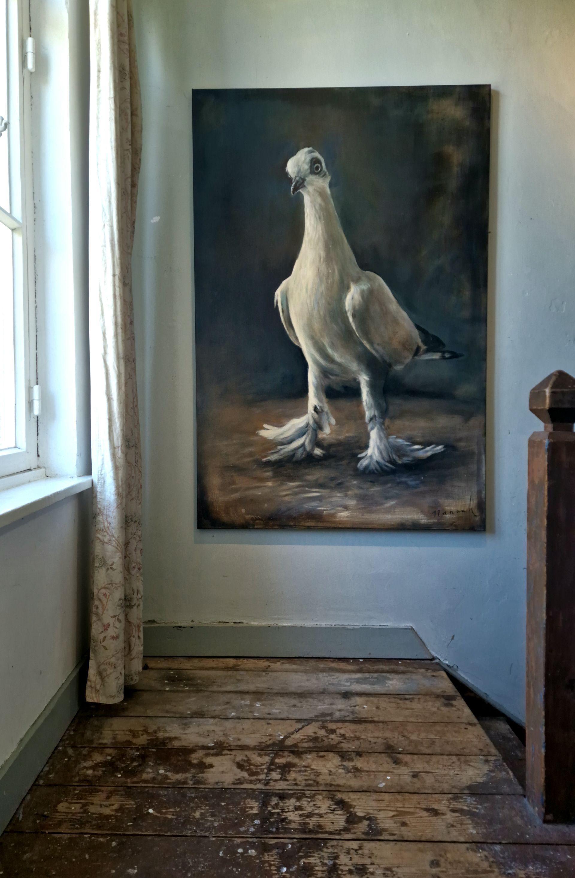 Een groot schilderij van een duif hangt aan de muur in een kamer.