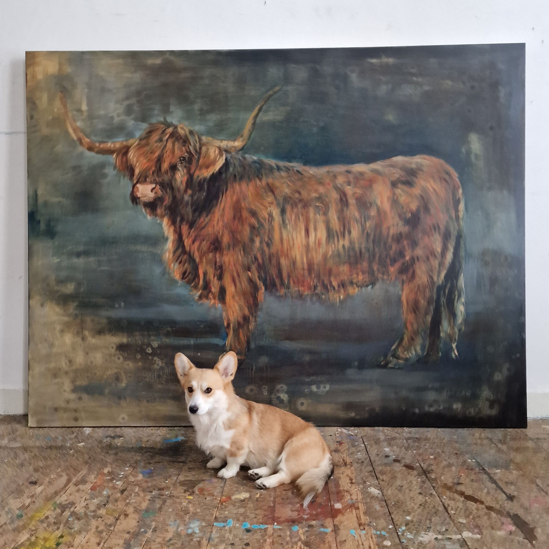 Een hond zit voor een schilderij van een koe