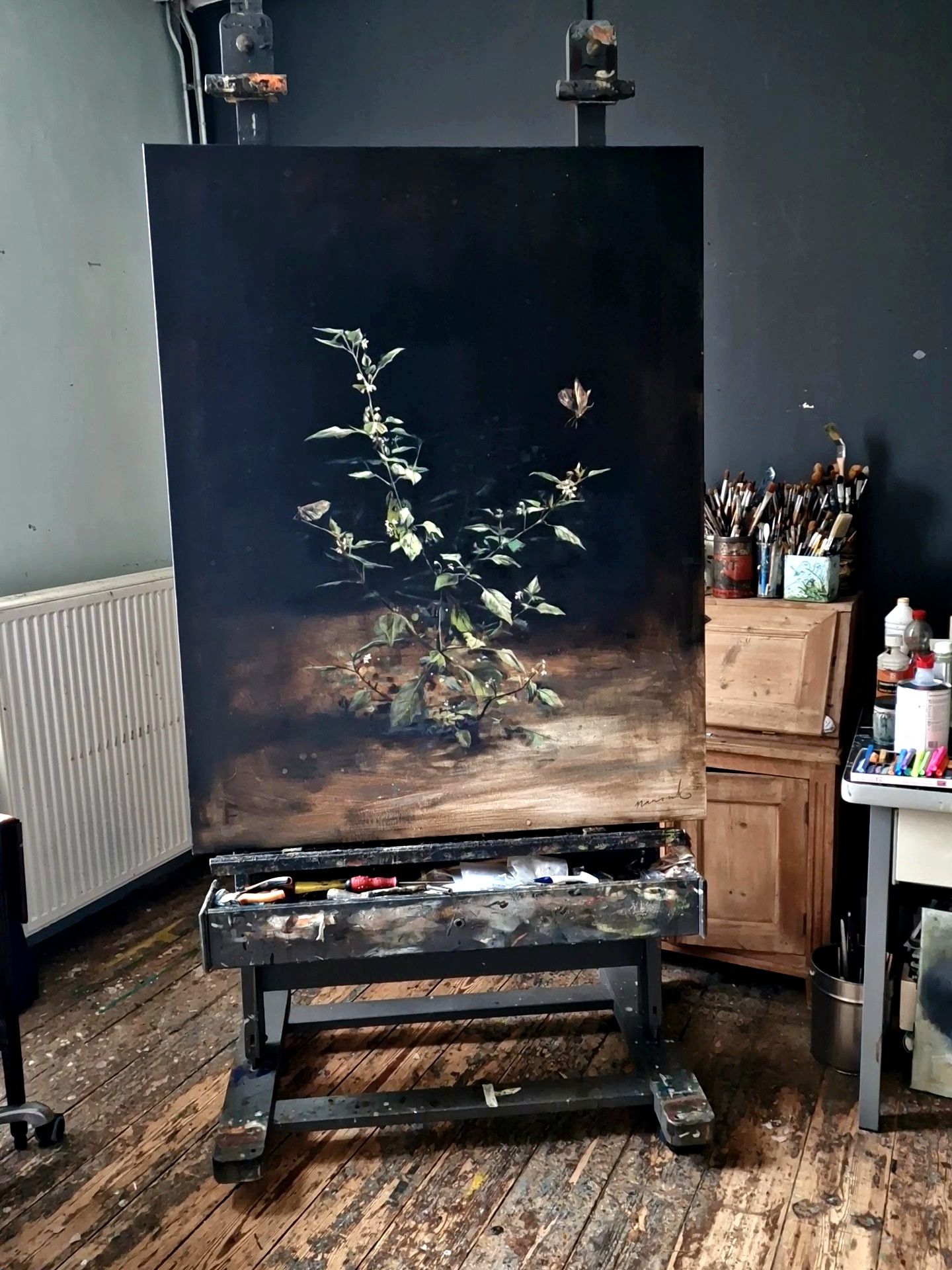 Een groot schilderij staat op een ezel in een kamer.