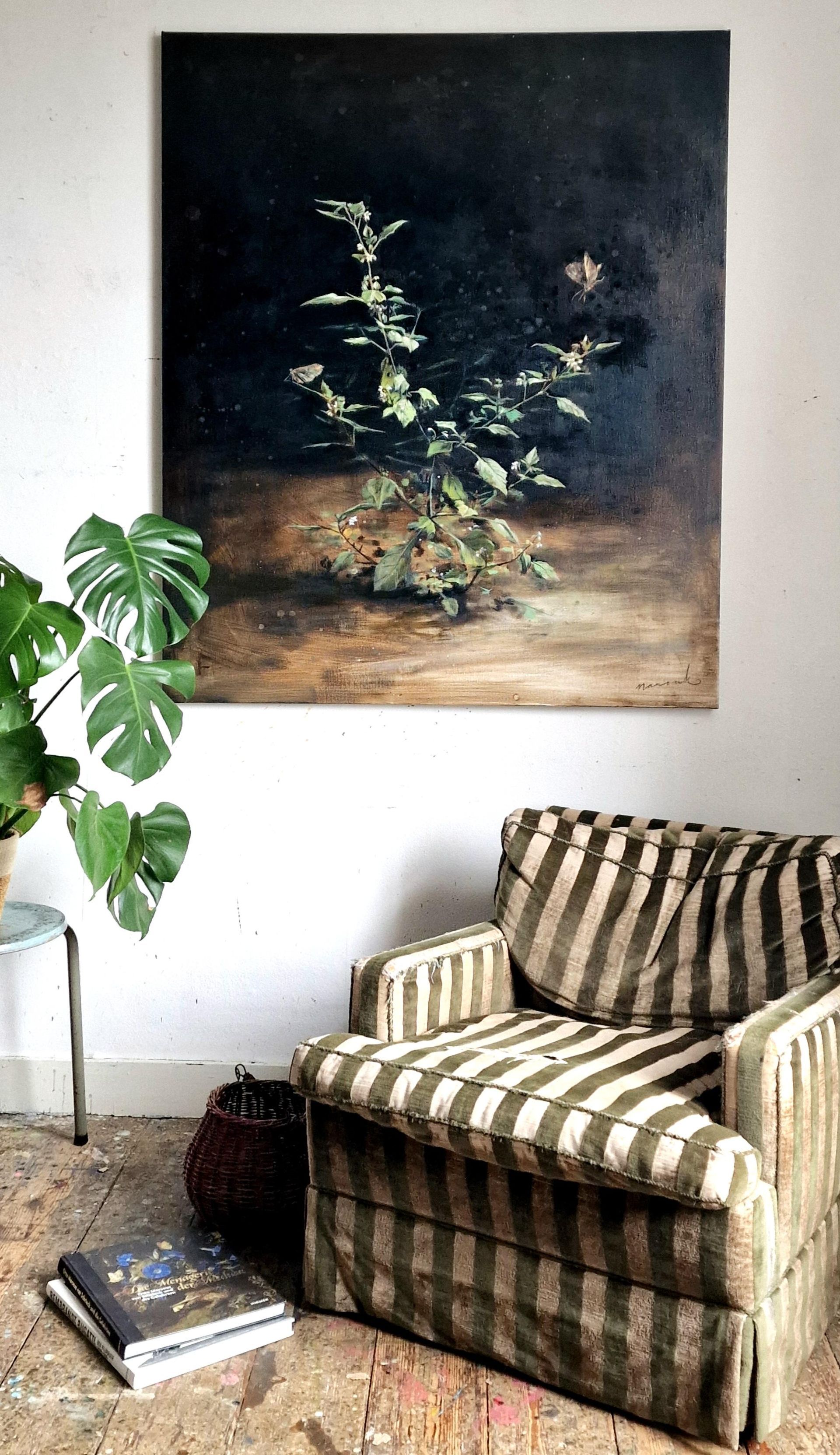 Een woonkamer met een stoel en een schilderij aan de muur.