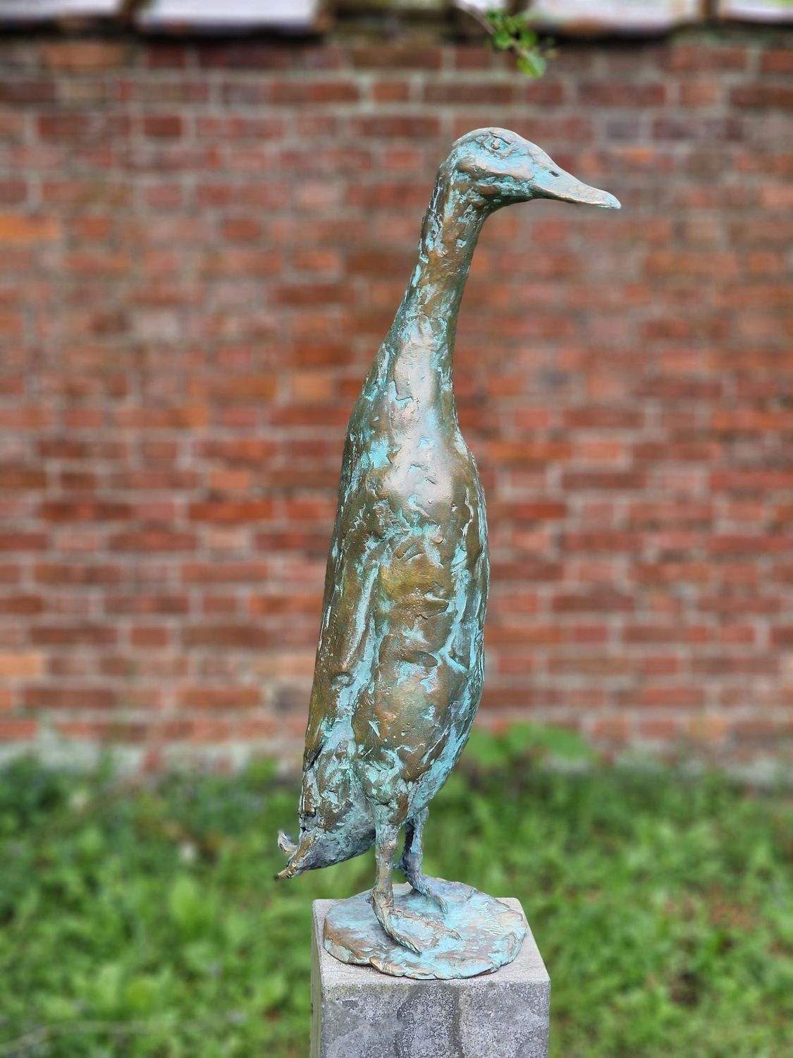 Een bronzen beeld van een loopeend 
