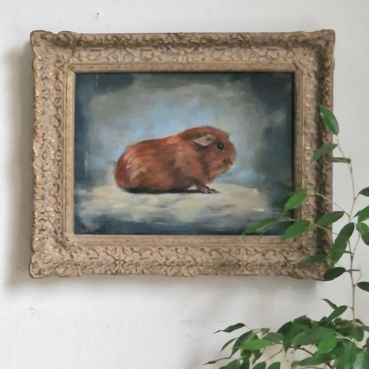 Een ingelijst schilderij van een cavia die op een rots zit