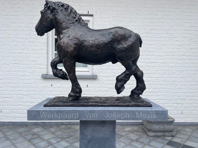 Een beeld van een paard met de naam werkpaard van joseph movis erop geschreven