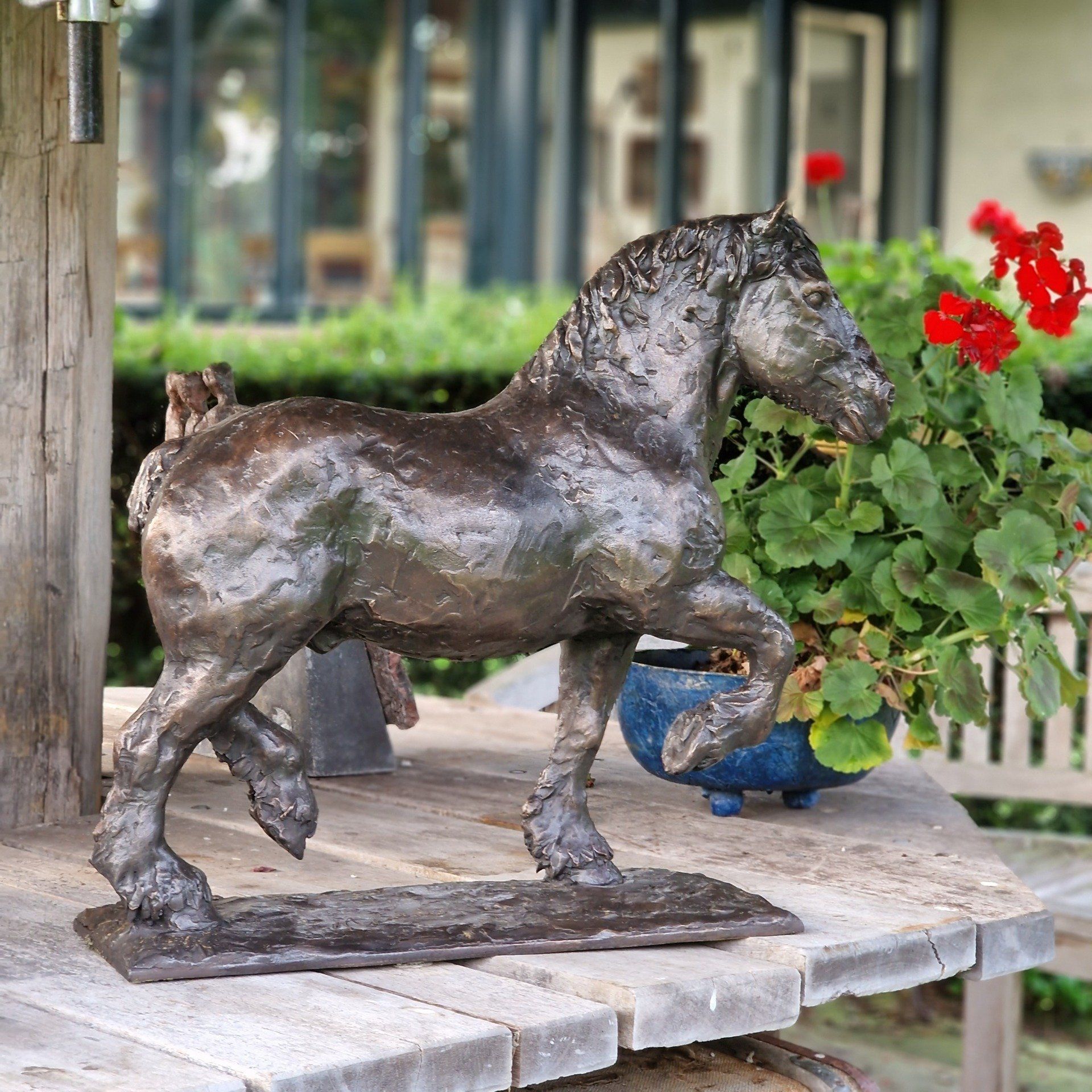 Een standbeeld van een paard zit op een houten tafel