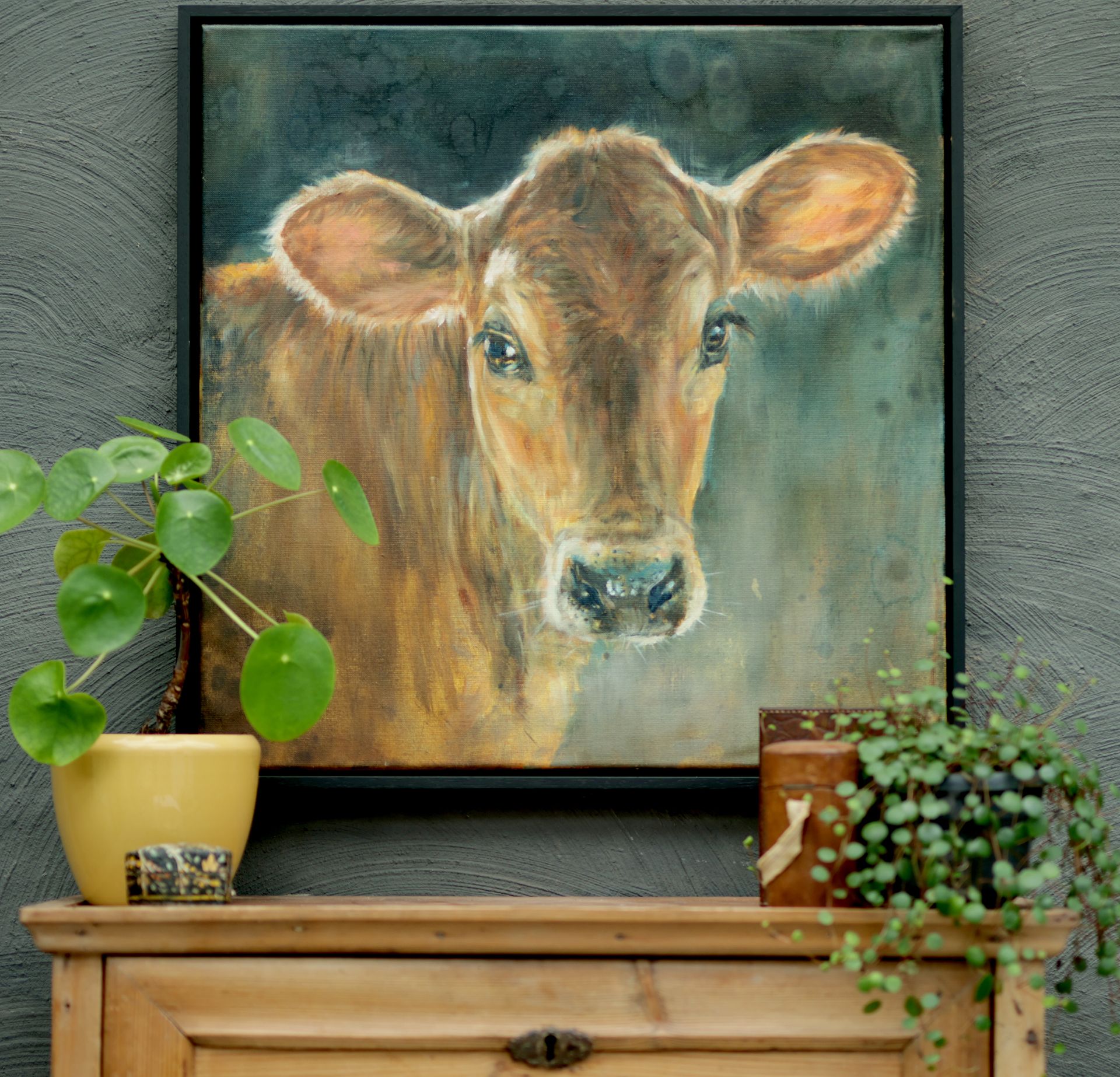 Aan de muur hangt een schilderij van een koe