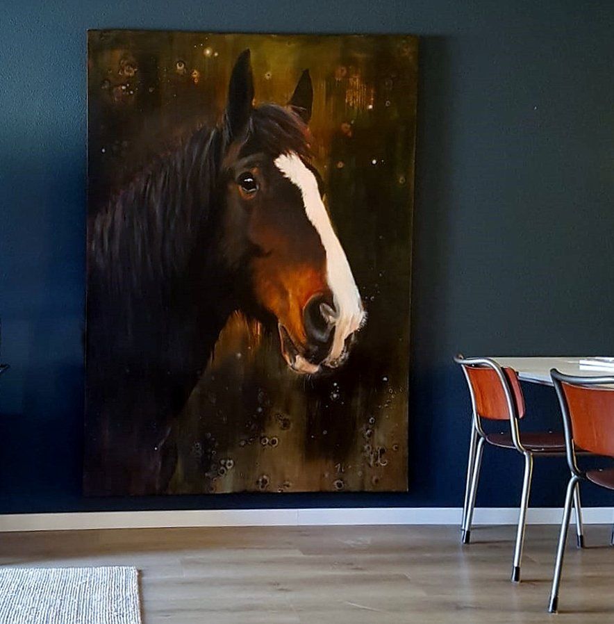 Een groot schilderij van een paard hangt aan de muur