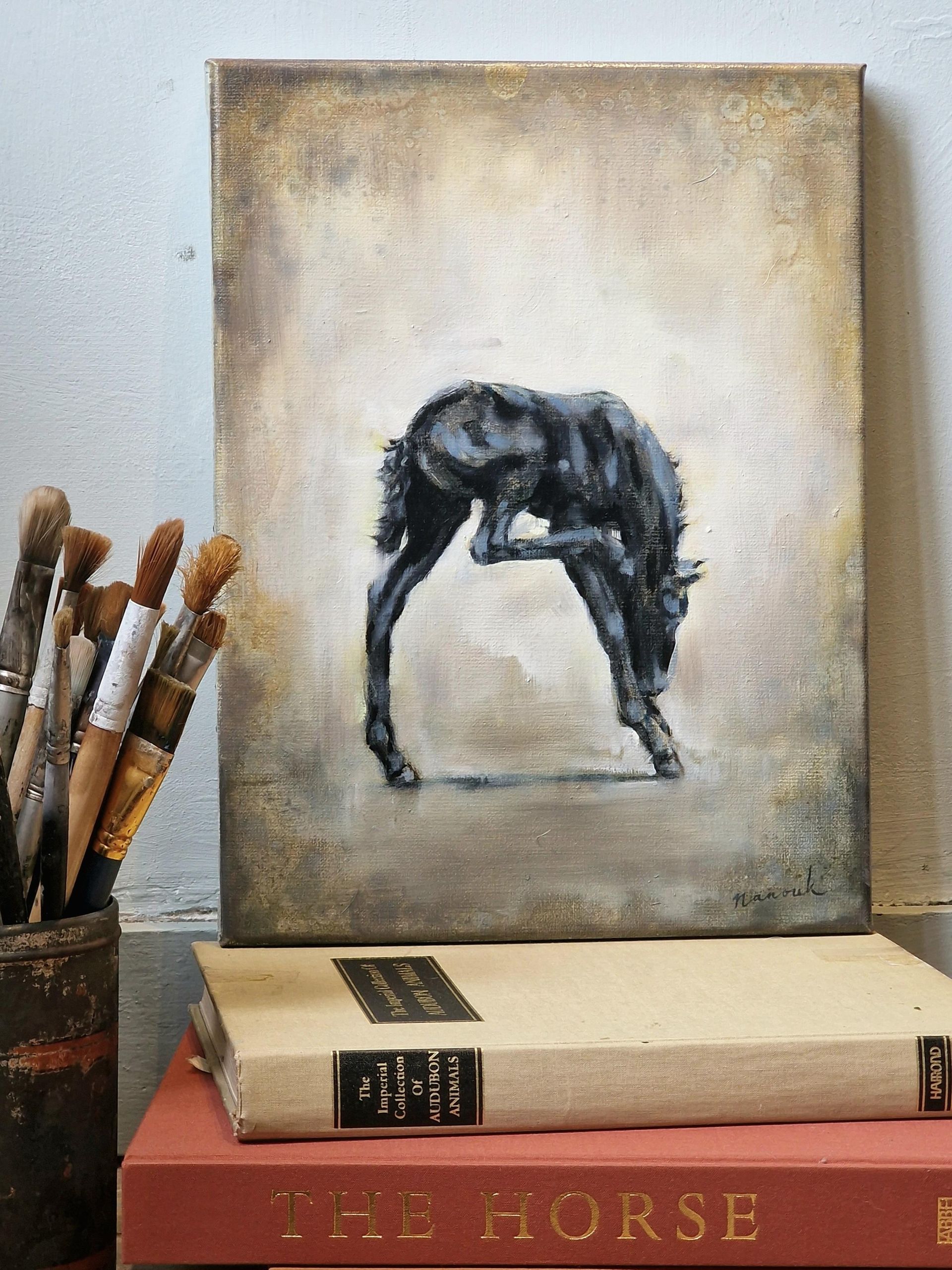 Een schilderij van een paard zit bovenop een stapel boeken