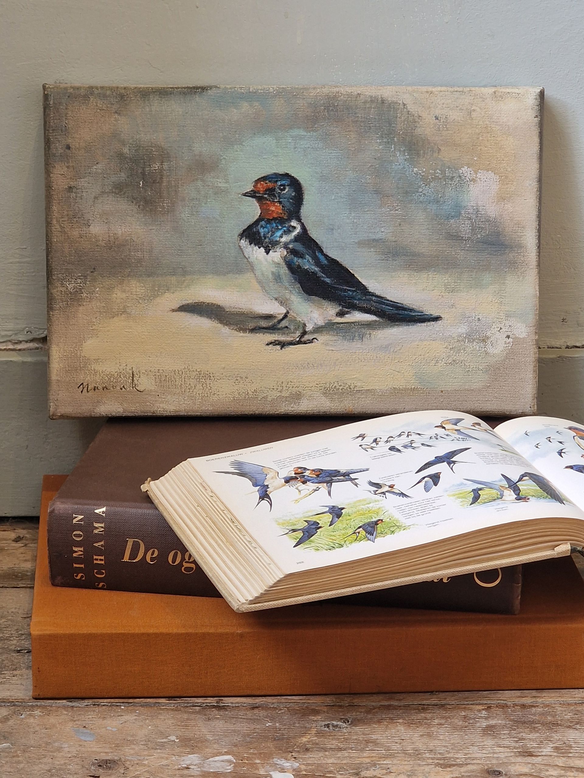 Een schilderij van een vogel die bovenop een stapel boeken zit.