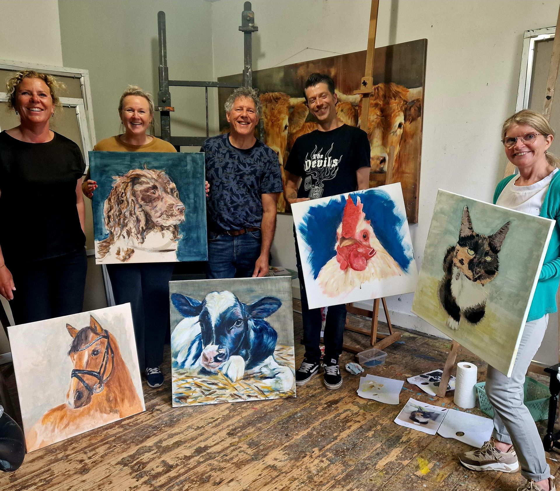 Een groep mensen staat in een kamer met schilderijen van dieren in hun handen.