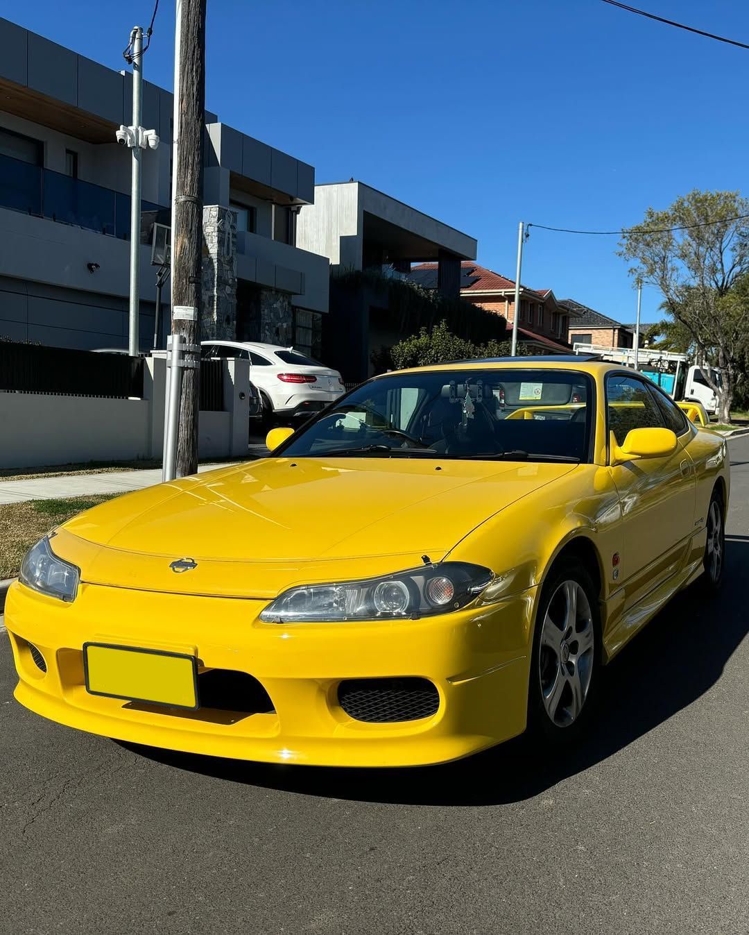 Yellow sports car parked on a street in front of buildings on a sunny day — Amrix Automotive In Bankstown, NSW