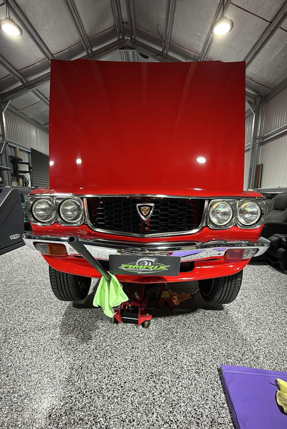 Red Classic Mazda Rx-3 With the Hood Open, Raised on a Jack in a Garage — Amrix Automotive In Parramatta, NSW