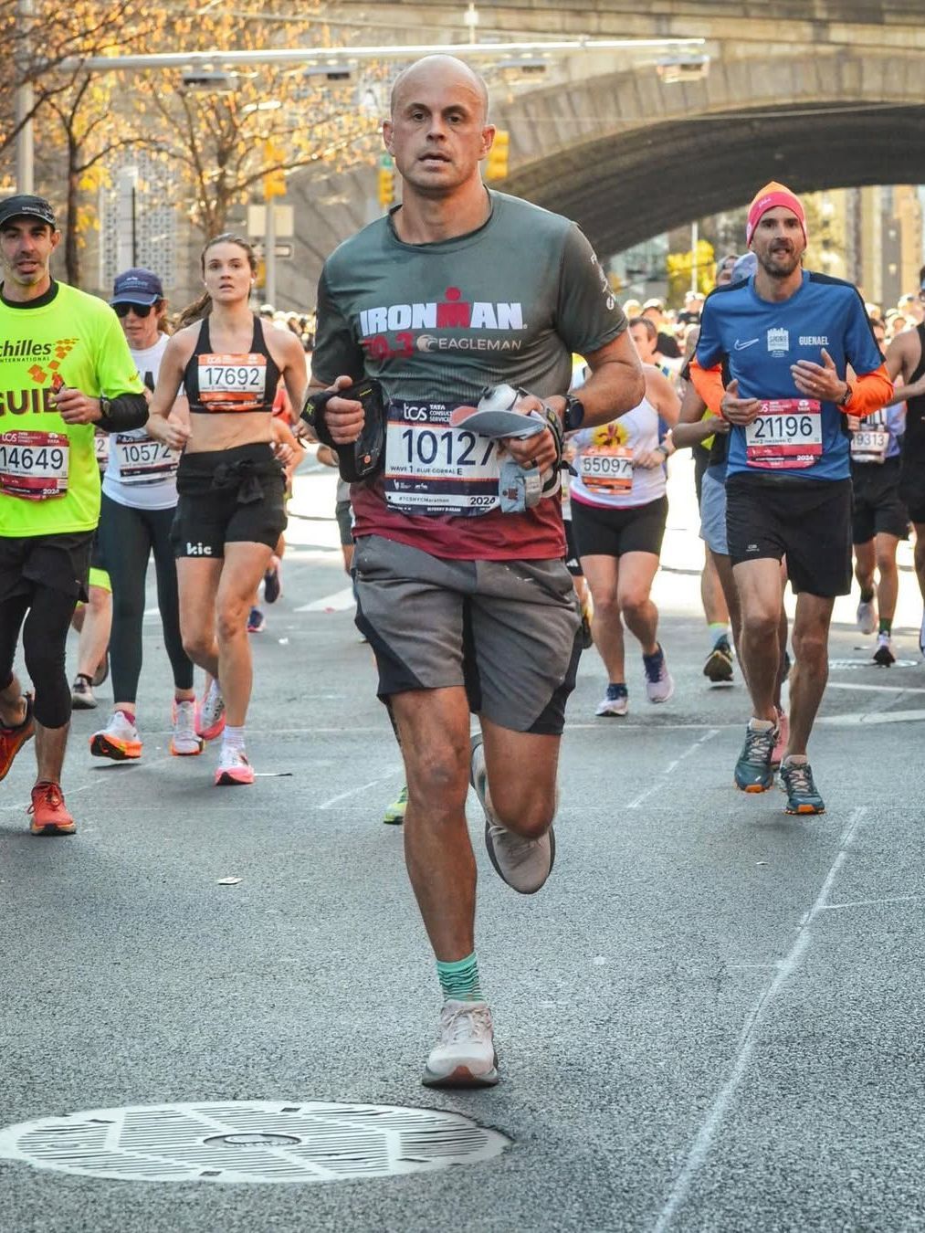 A man in an Ironman shirt is running in a marathon