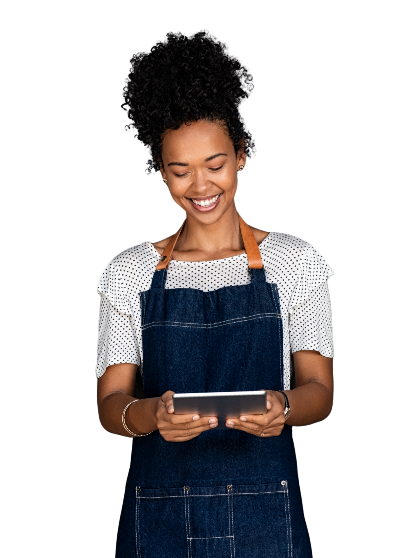 Woman in apron smiles, looking at tablet.