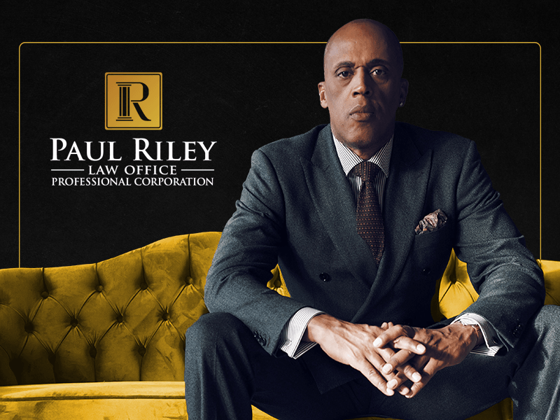 A man in a suit and tie is sitting on a yellow couch.