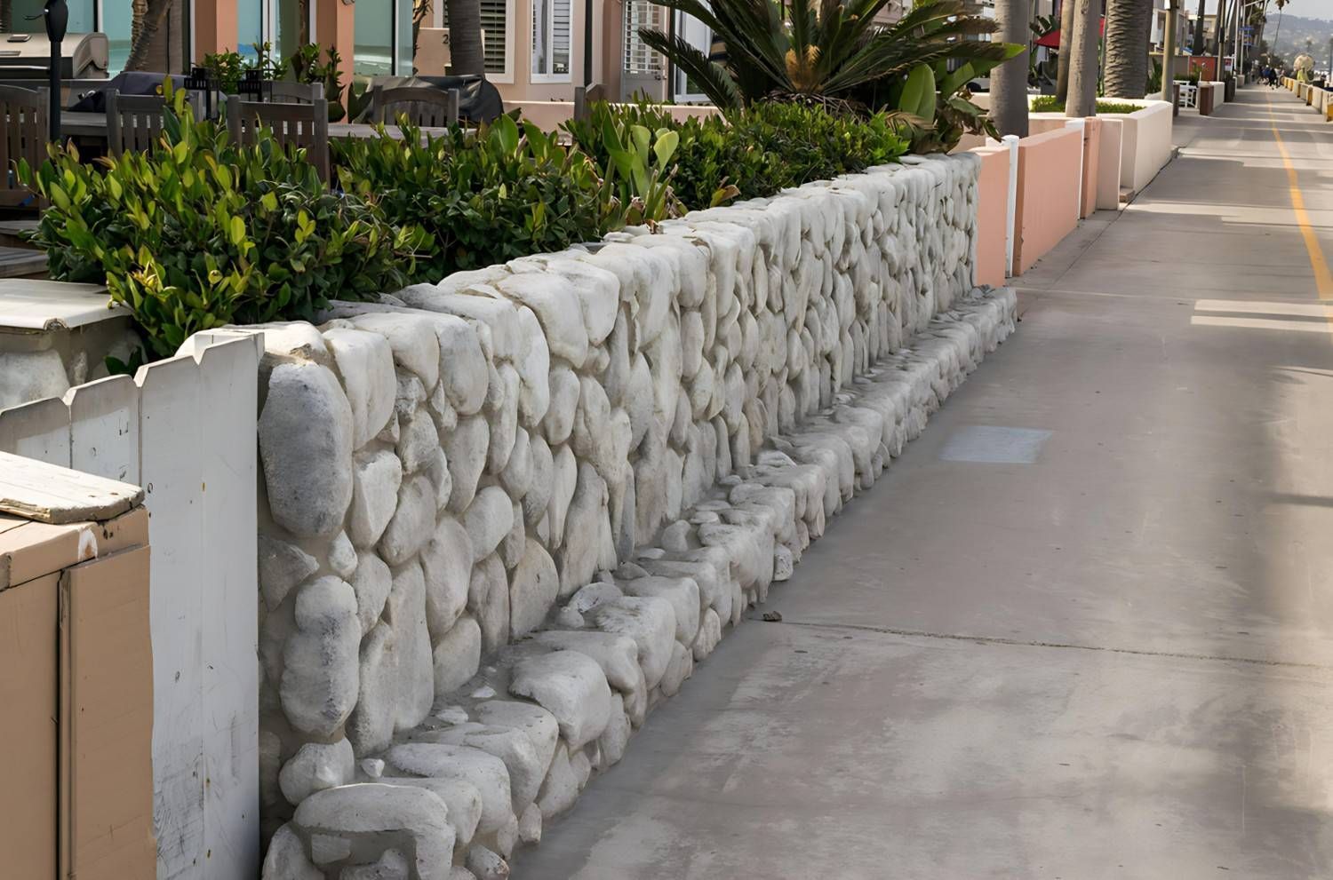 A Stone Wall Along a Sidewalk Next to A Building — B3 Plumbing in Flynn, ACT
