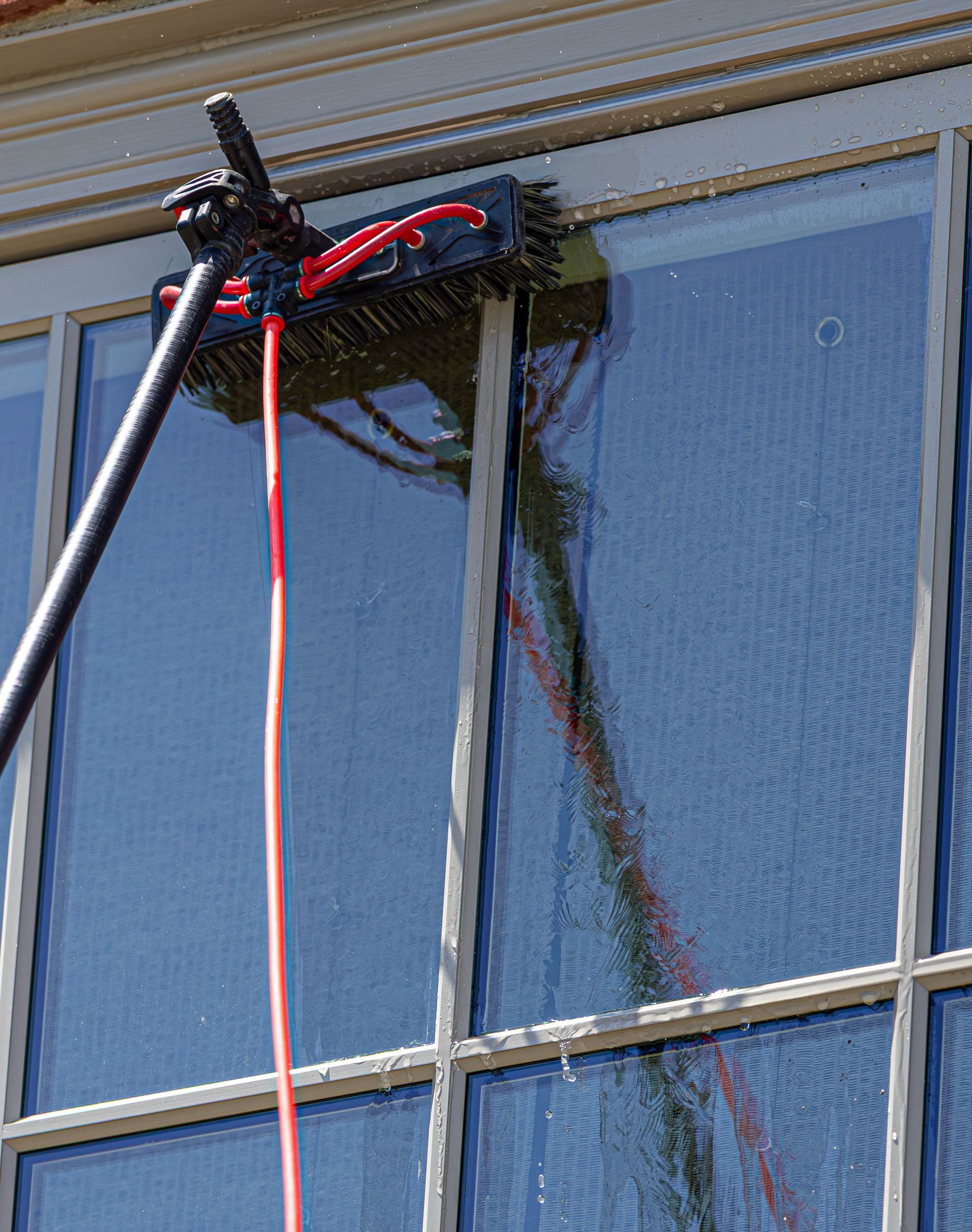 A window washer rope and harness hanging from the top of a blue building window.