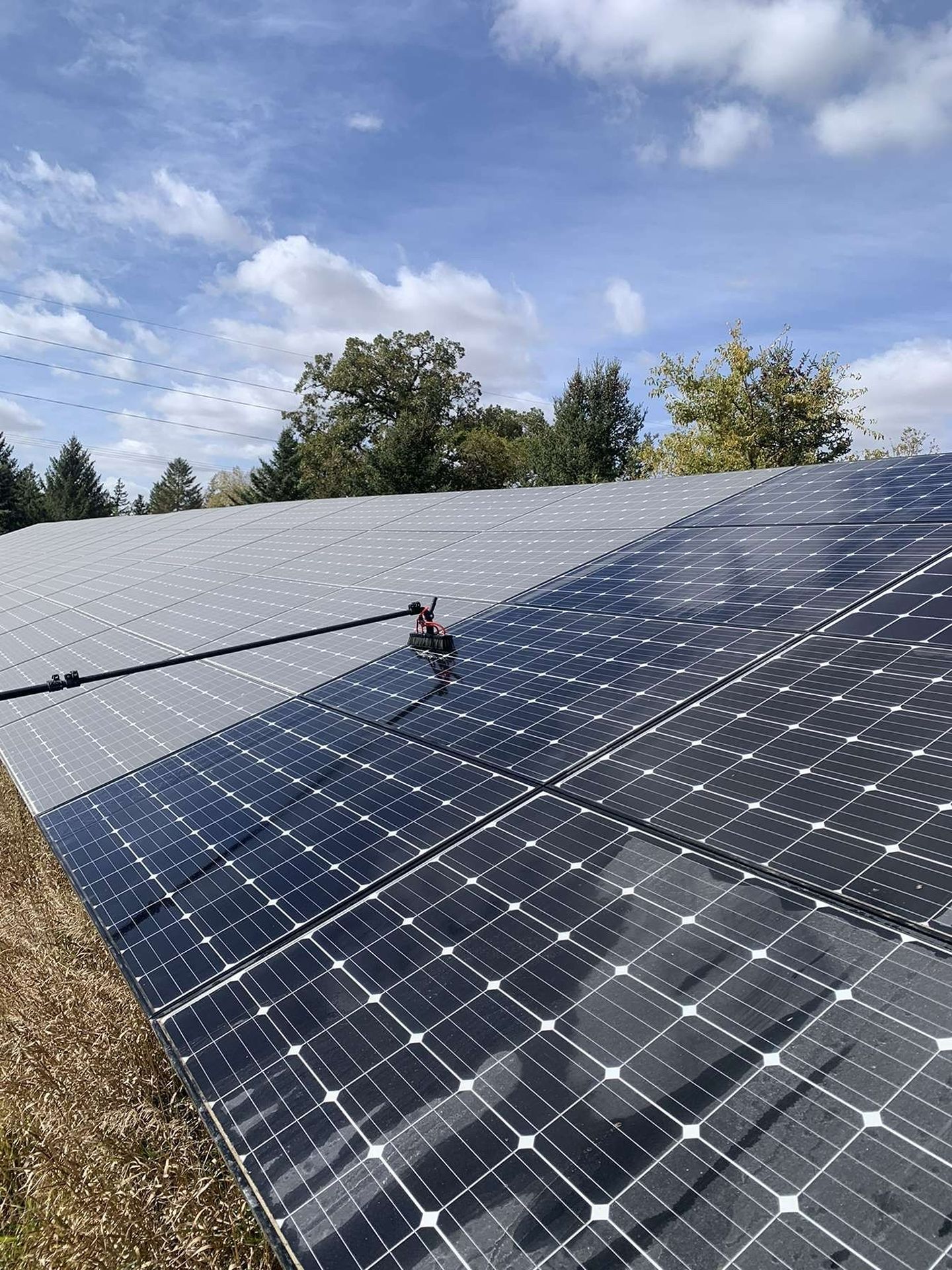 Rows of solar panels on a rooftop under a partly cloudy sky