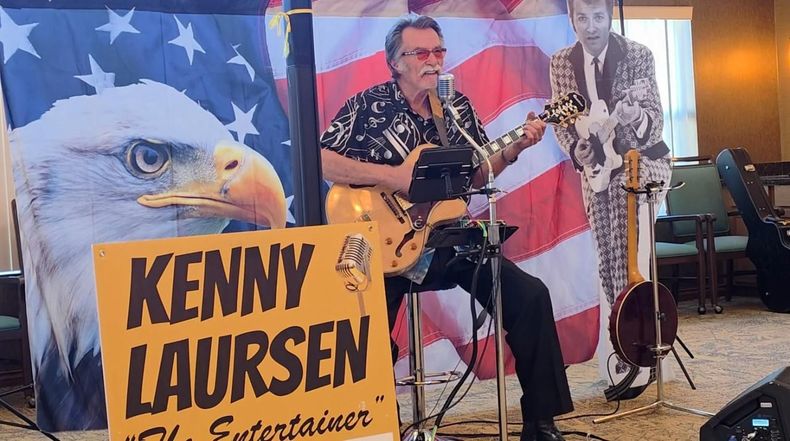 Musician Kenny Laursen sings and plays guitar onstage