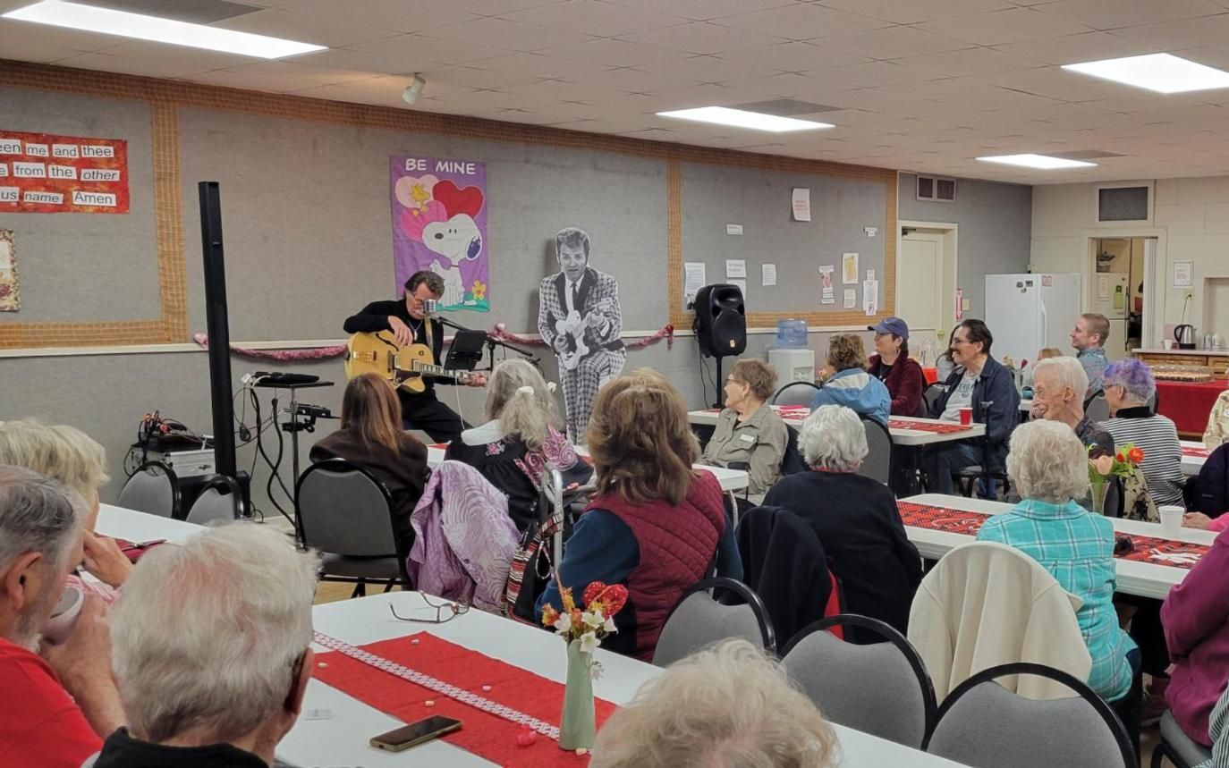 Audience seated in a community hall watching a presentation