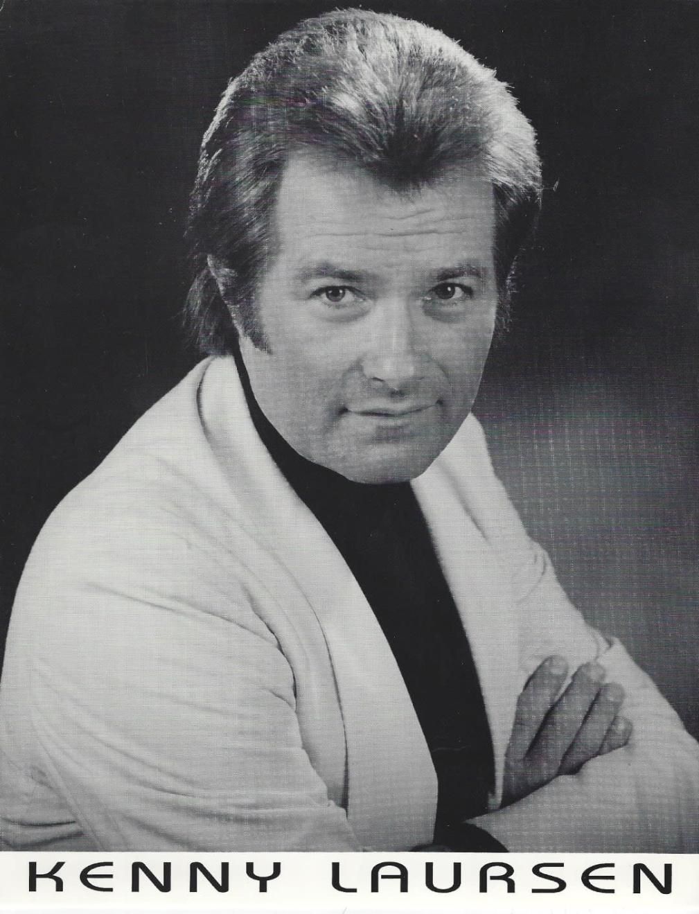 Black-and-white portrait of Kenny Laursen in a light jacket, arms crossed, with his name below.