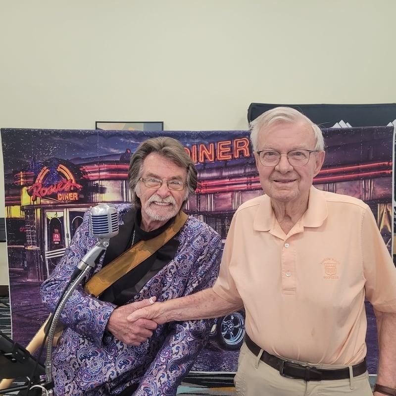 Two men smiling and shaking hands