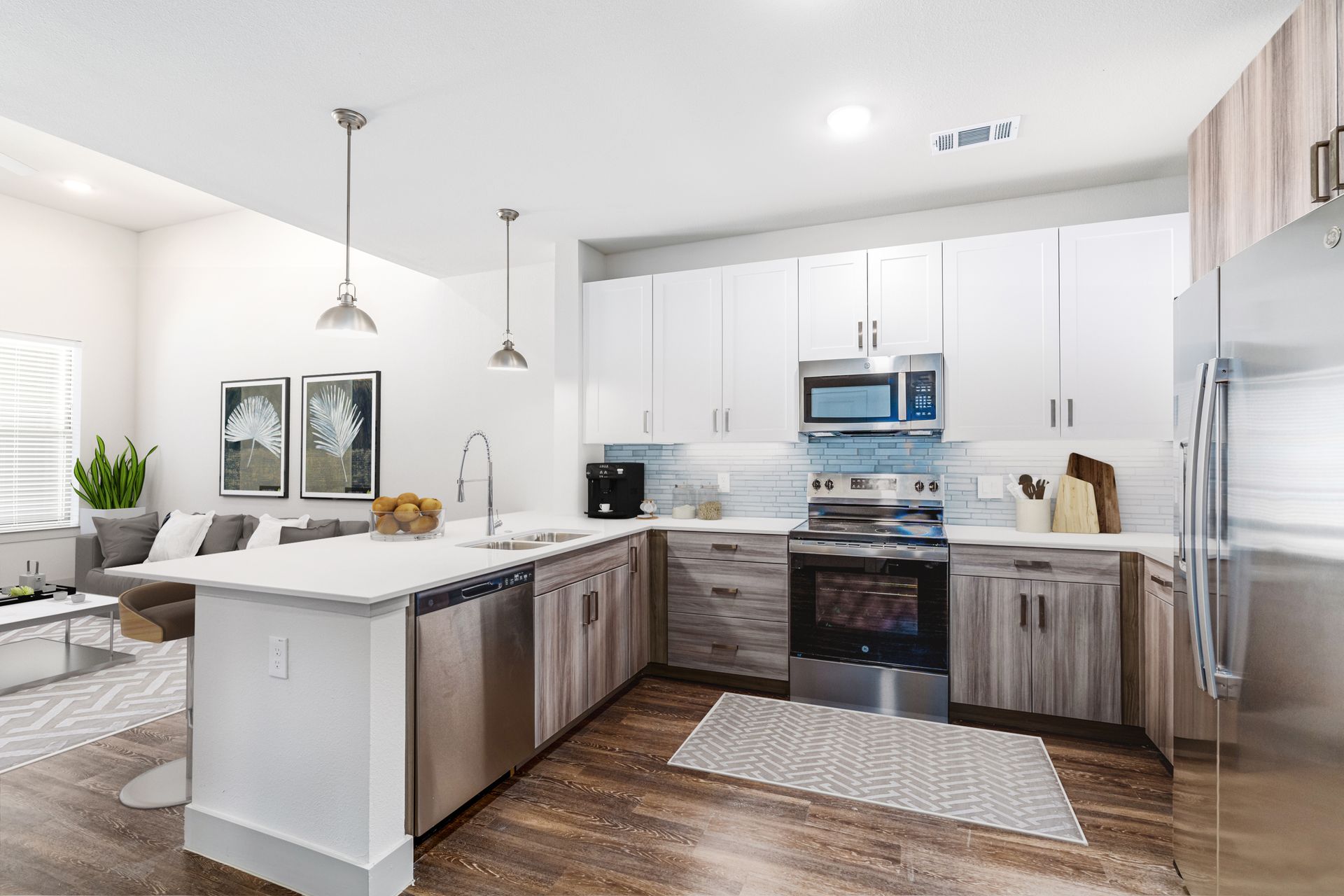 Bright modern kitchen with white cabinets, island, stainless appliances, and wood floors