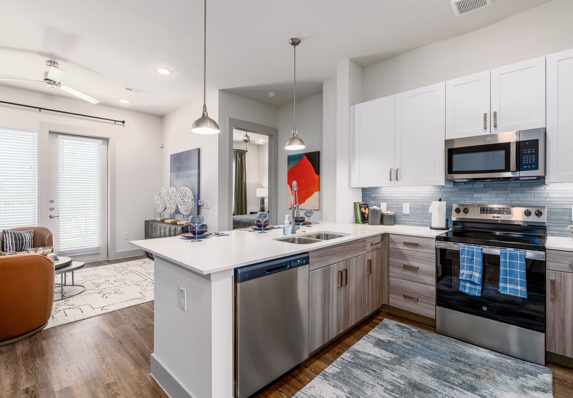 Bright modern kitchen with white cabinets, stainless appliances, island, and adjoining living area