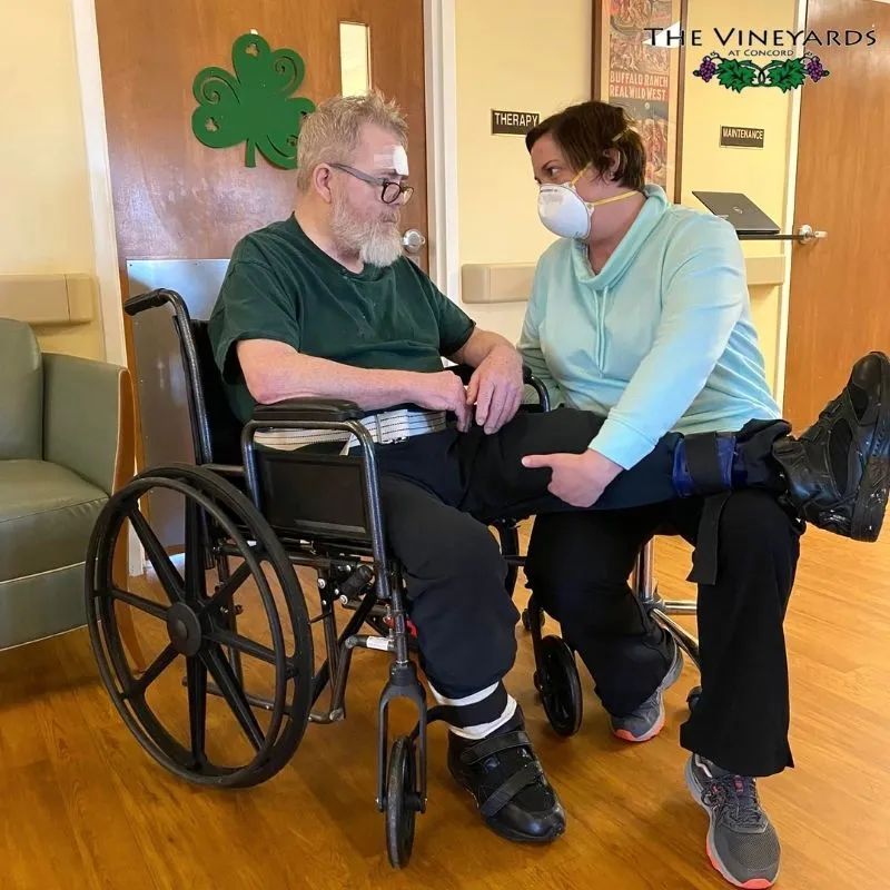 A man in a wheelchair and women helping him