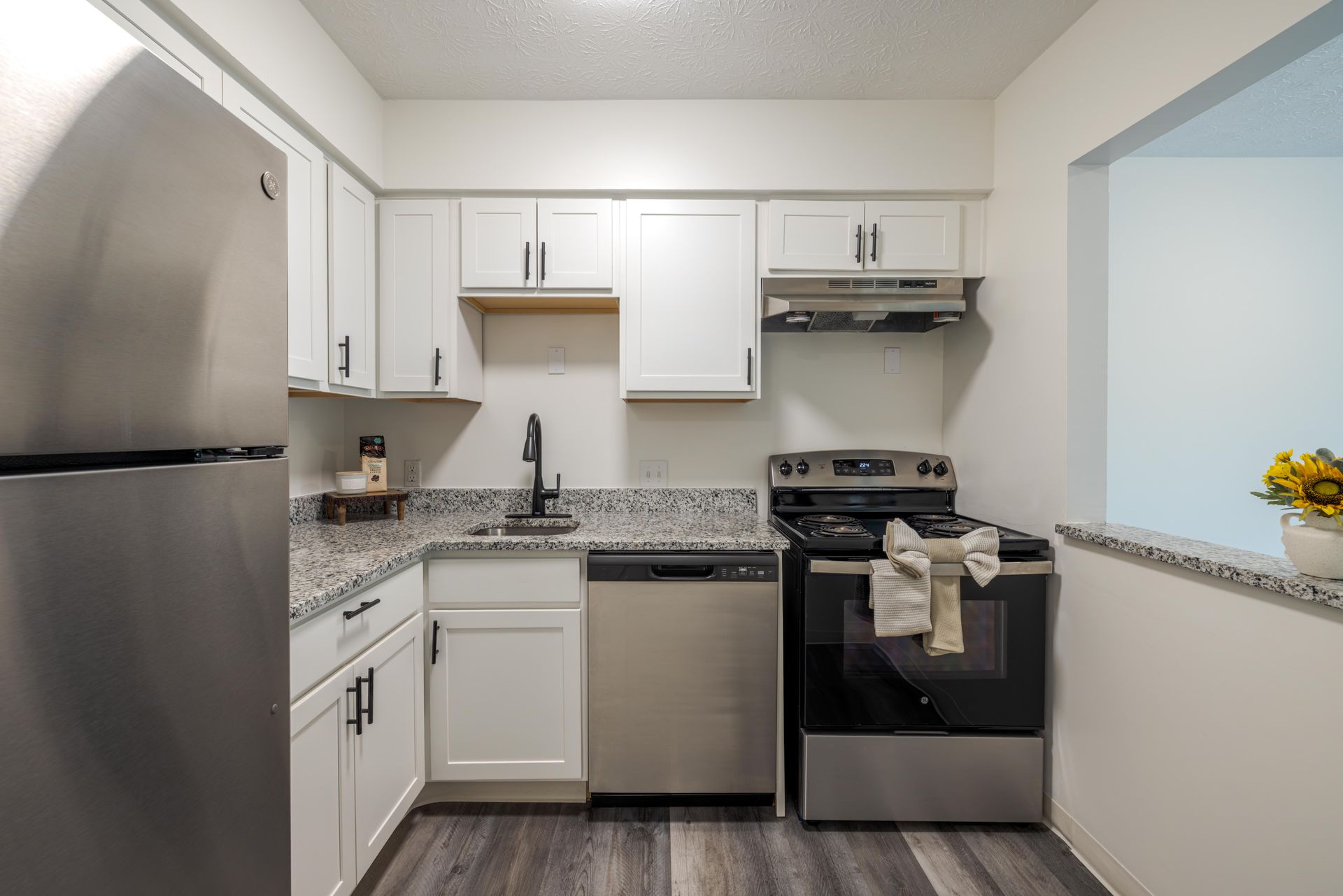 modern kitchen with white cabinets, stainless appliances, and a stainless fridge and stove. at the Reserves at Arlington in Columbus, OH.