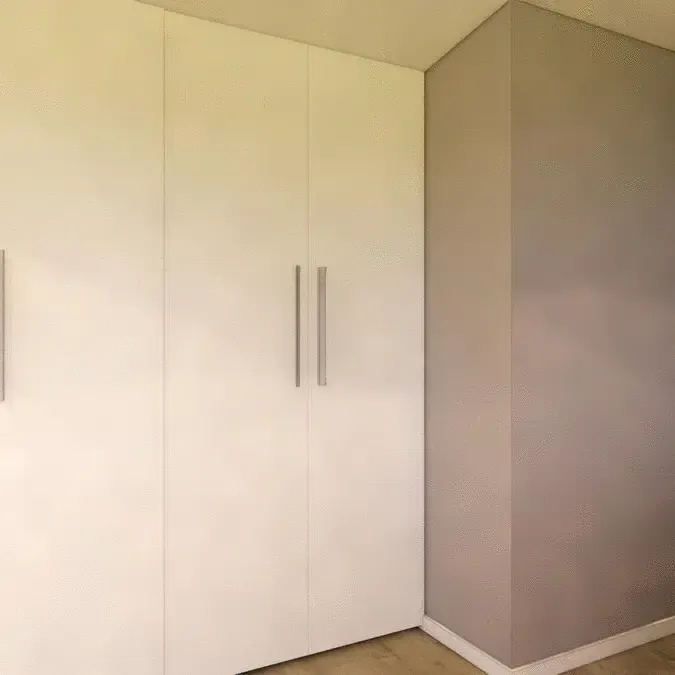 A room with white cabinets and a gray wall.