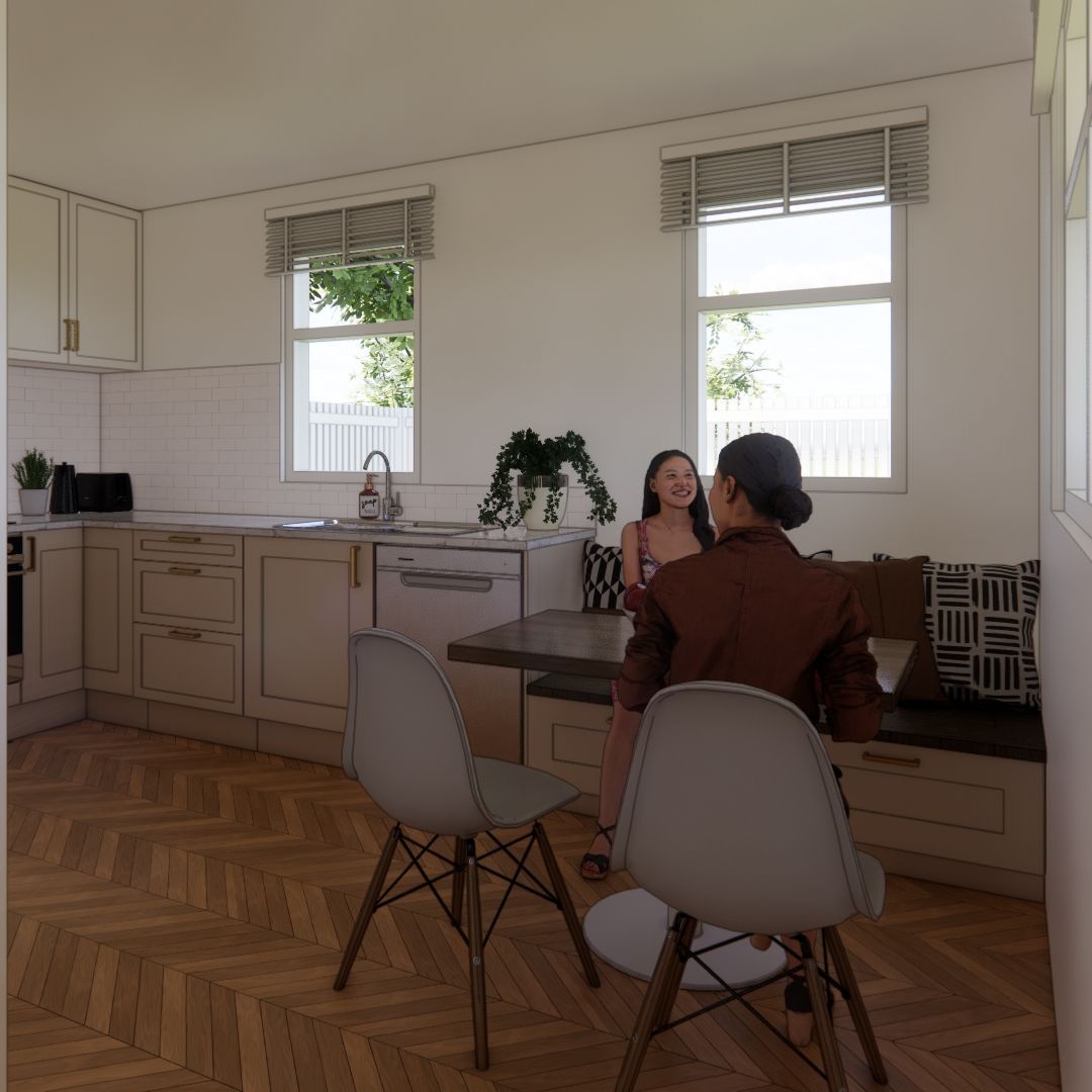Two women are sitting at a table in a kitchen talking to each other.