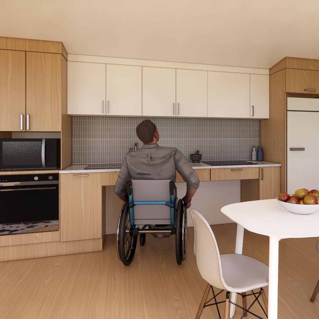 A man in a wheelchair is sitting at a table in a kitchen