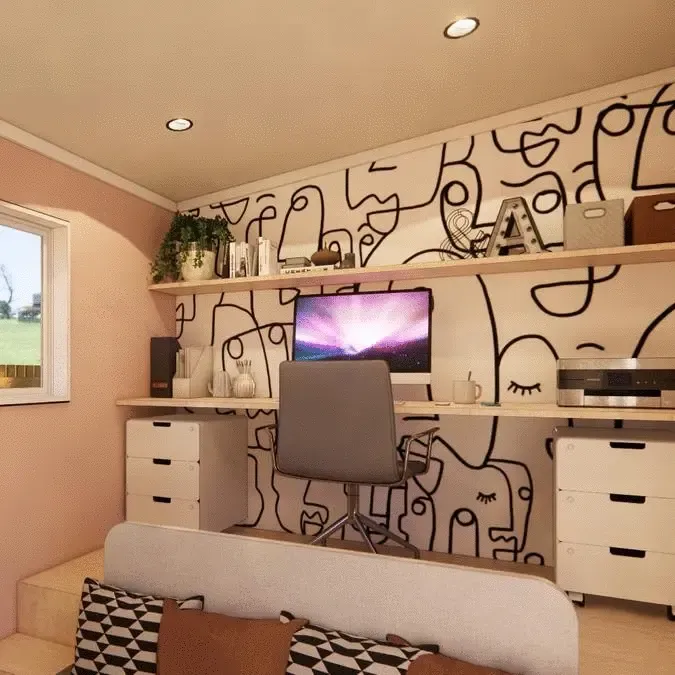 A computer is on a desk in a room with a mural on the wall