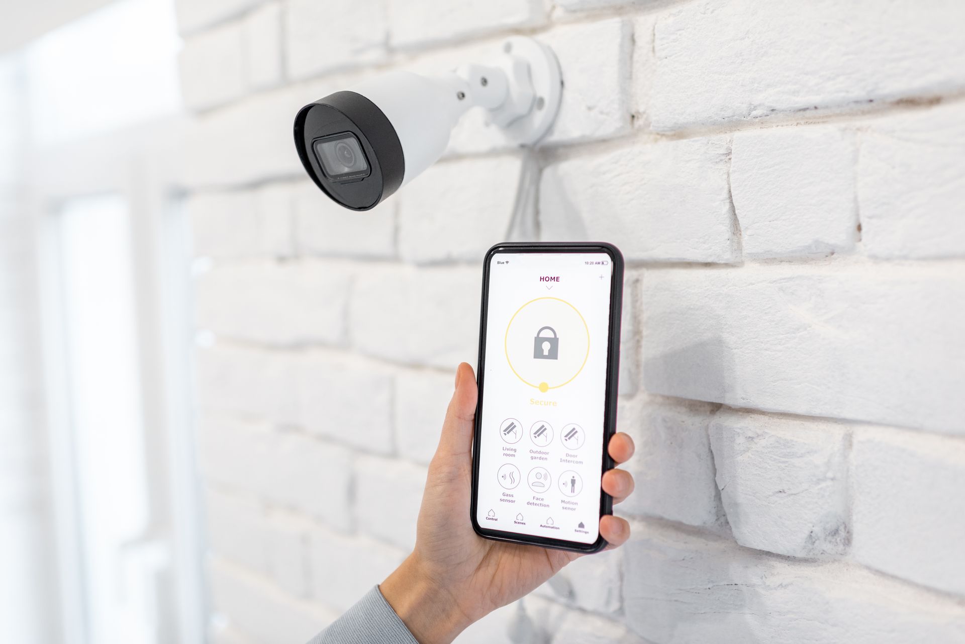 A close-up of a hand controlling video surveillance with a mobile.