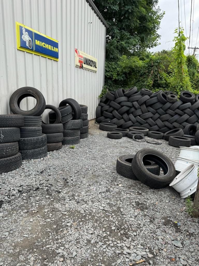 Exterior of a tire shop with a large pile of tires, Michelin sign.
