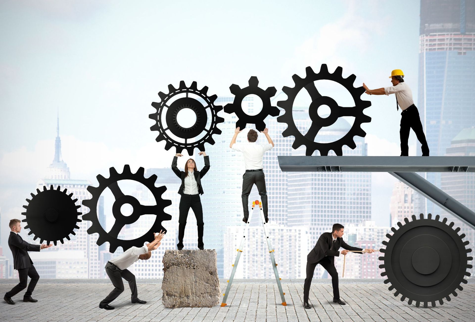 People assembling gears on a city rooftop, symbolizing teamwork and progress.