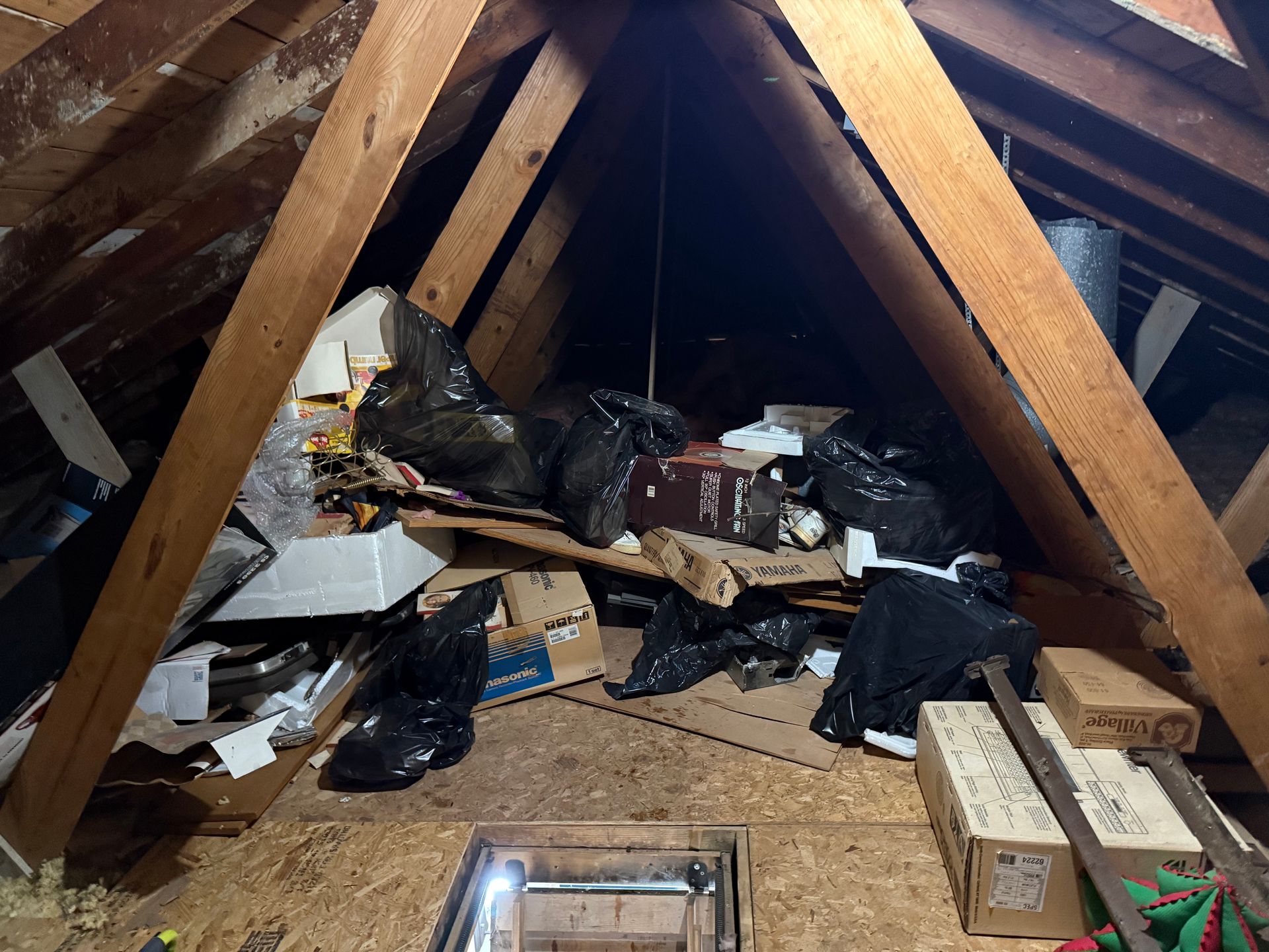 Attic bedroom with slanted ceiling, skylight, bed, white chair, beanbag, and radiator