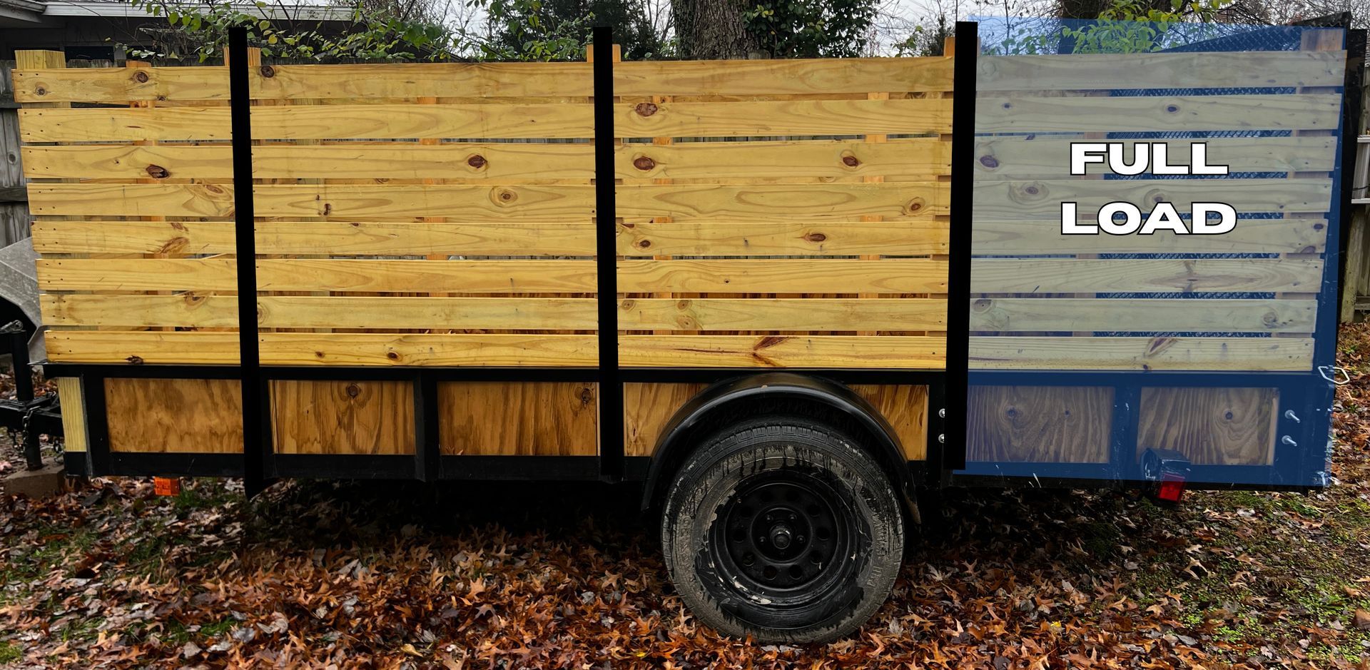 Blue dumpster overflowing with cardboard boxes and trash bags, recycling symbol on the side