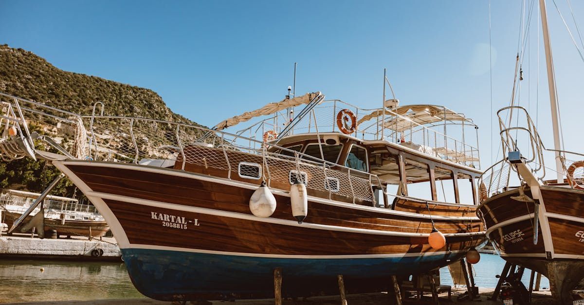 Wooden fishing boats docked in a harbor beside a rocky hillside